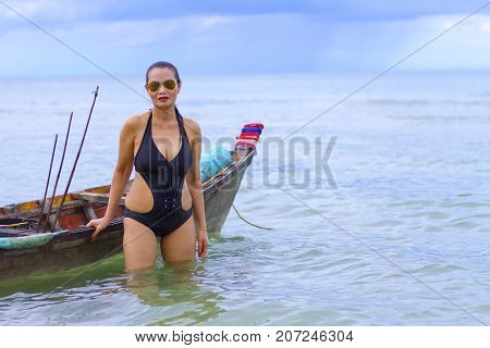 Woman sexy symbol black bikini and small boat on beach at Ban Krut Beach Prachuap Khirikhan Province Thailand
