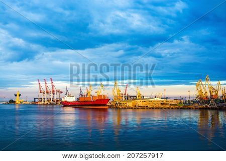 Panorama of the port. Cranes, ships, clouds and waves. Reflection in water.