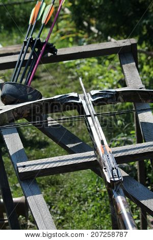 Crossbow, weapons producing boom.crossbow resting on tree trunk in autumn woods