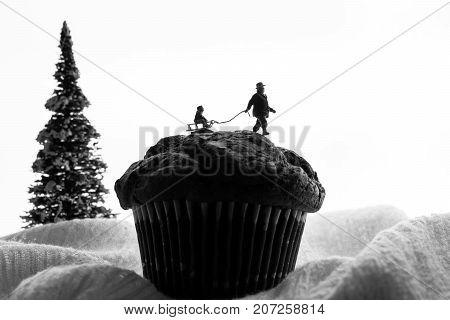 miniature man pulls a child on a sled
