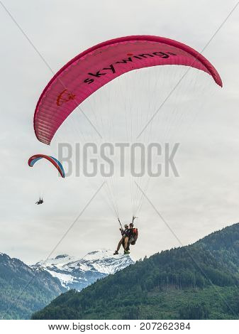 Interlaken Switzerland - May 26 2016: Paragliders above the Swiss Alps in Interlaken Switzerland.