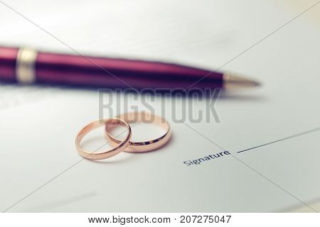 marriage contract - closeup of wedding rings on document