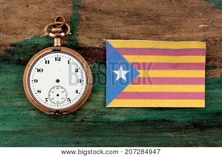 Old Clock And Flag Of Catalonia On Wood Background