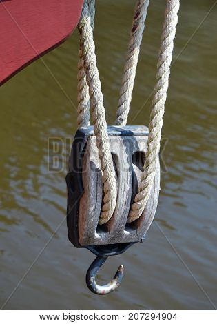 vertical image of ship pully hook above water