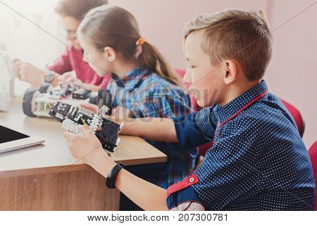 Children creating robots at school, stem education, copy space. Early development, diy, innovation, modern technology concept