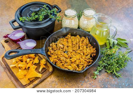 Chanterelle mushrooms with spices and herbs on a frying pan.