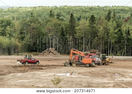 Clearcut forest deforest with machines trucks excavator in New Brunswick Canada