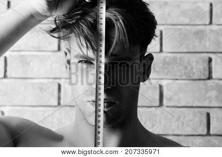 Guy With Builders Ruler Near Brick Wall. Worker With Roulette