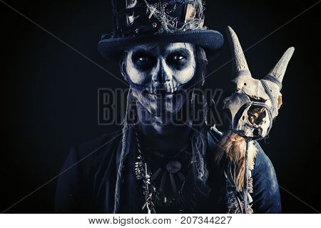 A man with a skull makeup dressed in a tail-coat and a top-hat. Baron Saturday. Baron Samedi. Dia de los muertos. Day of The Dead. Halloween.