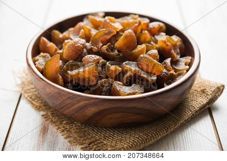 Ayurvedic Amla Candy, which is dried and salty-sweet or chatpata in taste and digestive. Served in a wooden bowl, selective focus