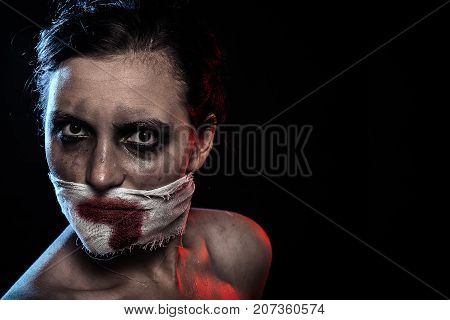 woman with wounded face and smeared cosmetics looking at camera