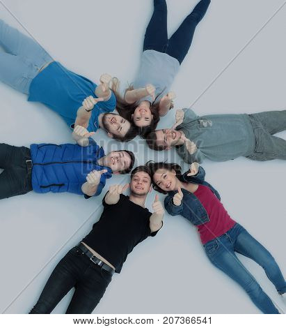 success concept - happy student team lying in a circle and holdi