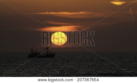 colorful sunset with boat silhouette off the coast of the Netherlands