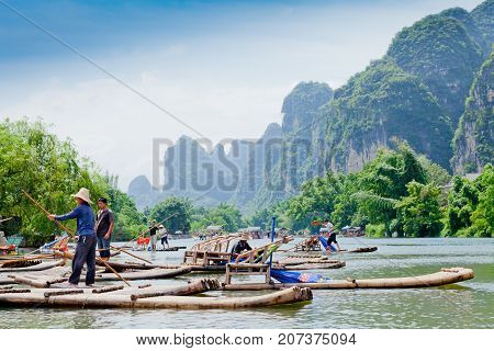 yulong river china July 2011: In July tourists travel on these bamboo rafts on the yulong river to admire the karst peaks covered with dense vegetation during an exciting water tour