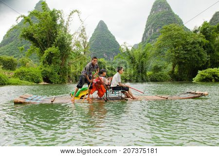 yulong river china July 2011: In July tourists travel on these bamboo rafts on the yulong river to admire the karst peaks covered with dense vegetation during an exciting water tour