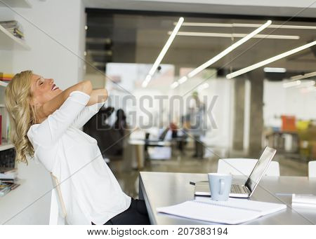 Businesswoman In The Office Taking A Break And Doing A Neck Exercise