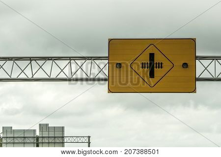 Railroad crossing warning attention lights sign in front of cloudy sky in canada