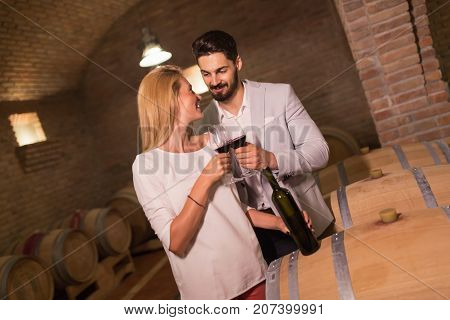Wine loving couple tasting wines in winery cellar
