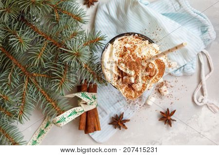christmas background: cocoa with cream and cinnamon on a concrete background top view