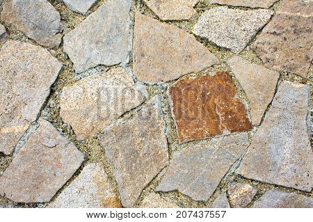 Masonry track made of yellow and brown large stones.