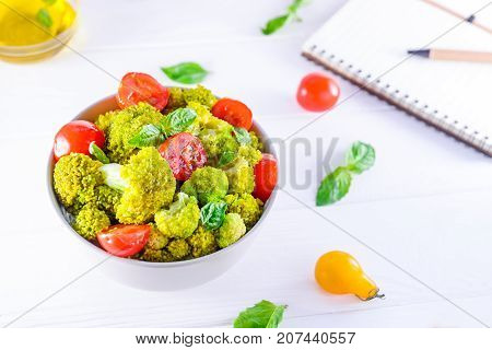 Top View Salad Bowl With Cherry Tomatoes, And Broccoli And Diet Notebook On The White Wooden Backgro