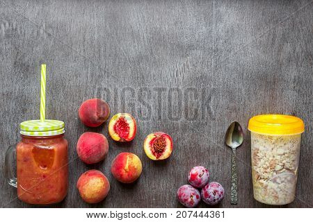 Fruit Smoothies. Peach and plum smoothie. Peach, plum and oatmeal. Delicious and healthy breakfast on wooden background. Top view. Copy space. Still life. Flat lay