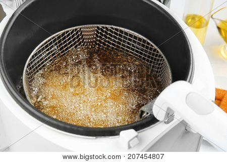 Deep fryer with boiling oil, closeup