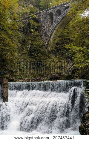 Nature autumn landscape. Waterfall at Soteska vintgar Slovenia. The Vintgar Gorge or Bled Gorge. Stone viaduct.