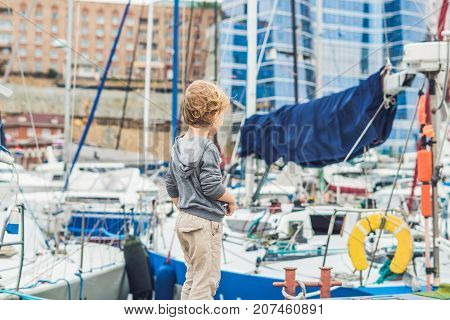Cute Blond Boy Looking At Yachts And Sailboats