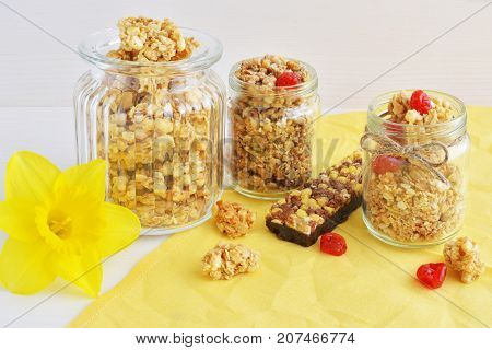 oat crunchy and crispy muesli bar with yellow narcissus flower over table with natural linen napkin background healthy breakfast concept