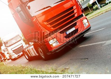 Trucks being driven on road picking up goods