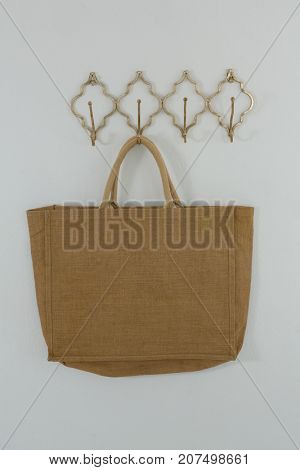 Bag hanging on hook against white wall
