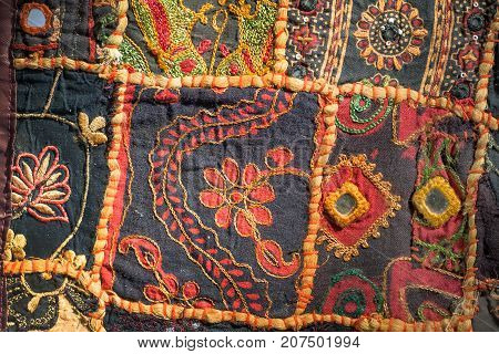 Vintage patchwork of retro handmade carpet. Patterns on texture of old blanket surface with flowers.