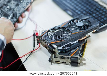Close-up of a man who repairs a video card. Cryptocurrency. Business and finance concept.
