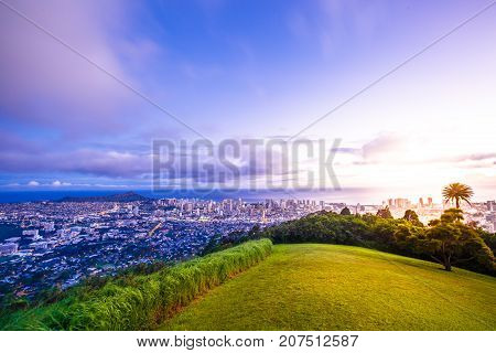 Tantalus Lookout at twilight, Puu Ualakaa State Park Honolulu. Tourists on panoramic city, Waikiki Beach and Diamond Head. Waikiki skyline Oahu Hawaii, United States. Vacation and travel concept.