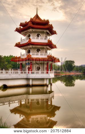 Sunset over Pagoda on a pond at Chinese Garden a free public park in Singapore. The garden is modeled after the Chinese imperial style of architecture and landscaping.