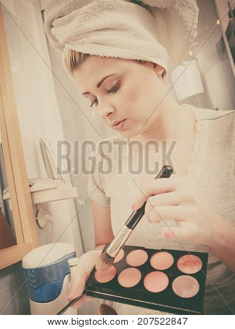 Woman In Bathroom Applying Contour Bronzer On Brush