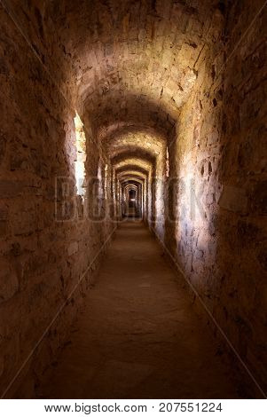 Interiors of castle, view through the stone tunnel with windows