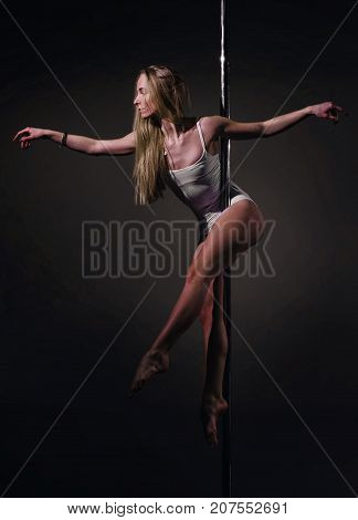 Sexy woman performing pole dance on pylon