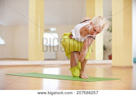 Beautiful sporty fit yogi woman practices yoga asana Parivritta Vatayanasana in the yoga class