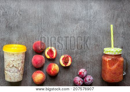Fruit Smoothies. Peach and plum smoothie. Peach, plum and oatmeal. Delicious and healthy breakfast on wooden background. Top view. Copy space. Still life. Flat lay