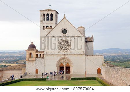 ASSISI ITALY 30 JUNE 2017: Famous Basilica of St. Francis of Assisi (Basilica Papale di San Francesco) with Lower Plaza at sunset in Assisi Umbria Italy