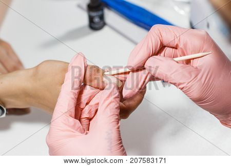 Hardware manicure in the salon. The master removes the cuticles close-up.