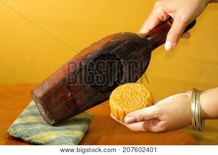 Chef's hand pulling moon cake out from wooden mold, home made Moon cake, traditional dessert made from du-rian for Chinese mid autumn festival, gourmet asian restaurant