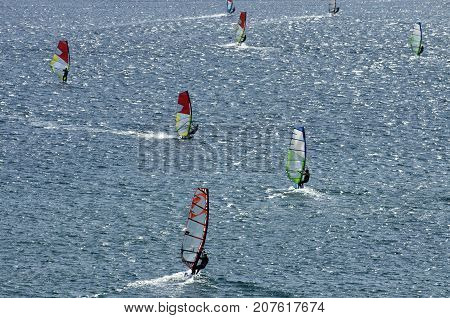 Windsurfers on the shining waves of the Mediterranean sea at Cape Prasonisi (Greece)