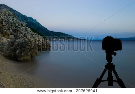 Camera on tripod with ocean and sunset in background / Podgora, Croatia