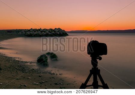 Camera on tripod with ocean and sunset in background / Podgora, Croatia