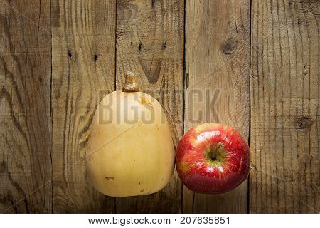 Butternut Squash Pumkpin Ripe Red Apple on Weathered Wood Background. Autumn Fall Thanksgiving Harvest. Copy Space Greeting Card Poster Template. Creative Conceptual Image