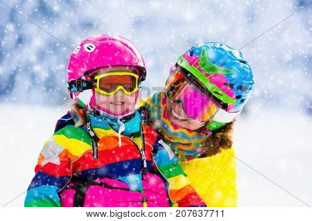 Family ski vacation. Group of skiers in Swiss Alps mountains. Mother and child skiing in winter. Parents teach kids alpine downhill skiing. Ski gear and wear safe helmets.