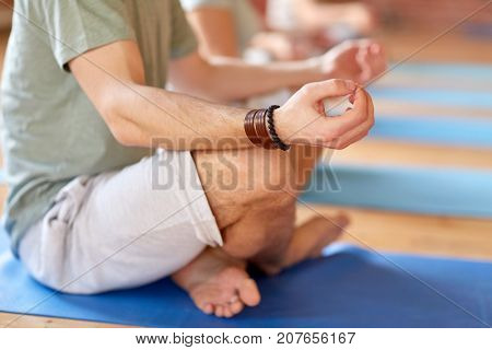fitness, yoga and healthy lifestyle concept - group of people meditating in lotus pose at studio